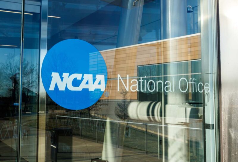 Close up of NCAA National Office signage on a glass door, representing the NCAA NIL lawsuit.