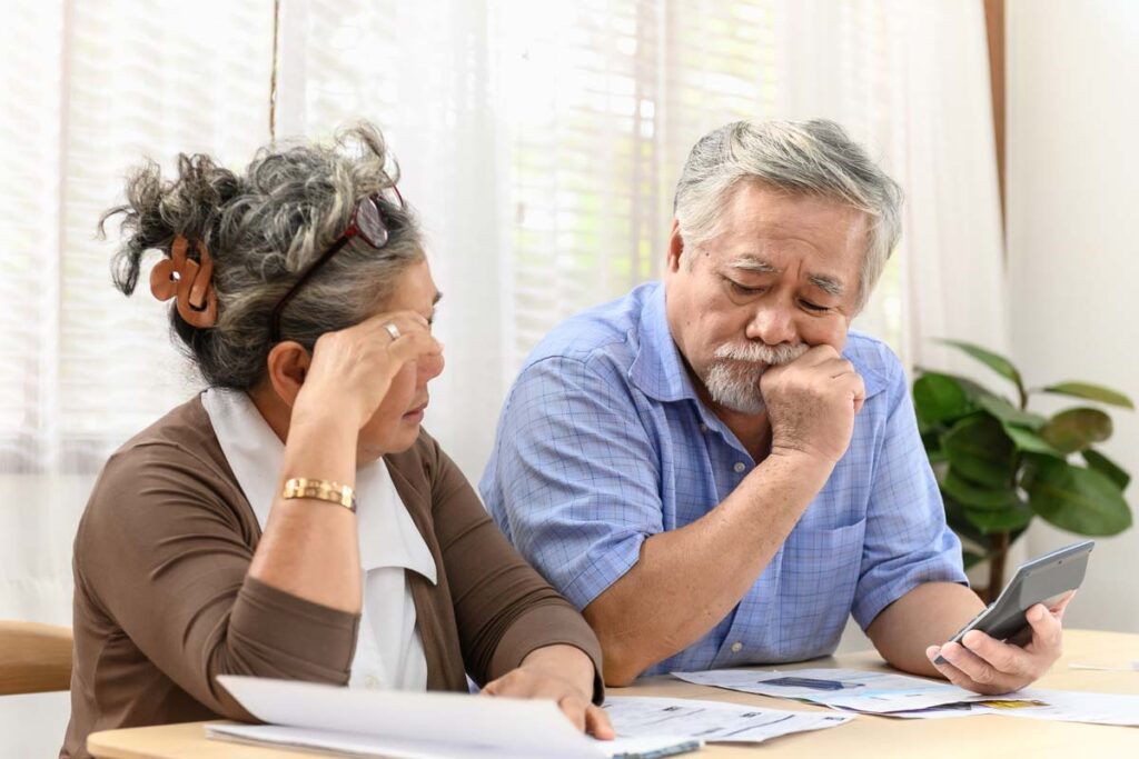 Confused elderly asian couple looking at documents, representing the PACE settlement.