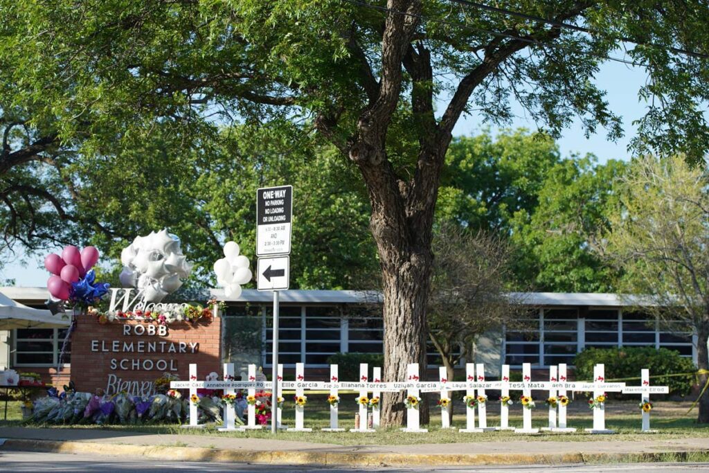 Exterior of Robb Elementary School with a memorial out front, representing the Uvalde lawsuits.
