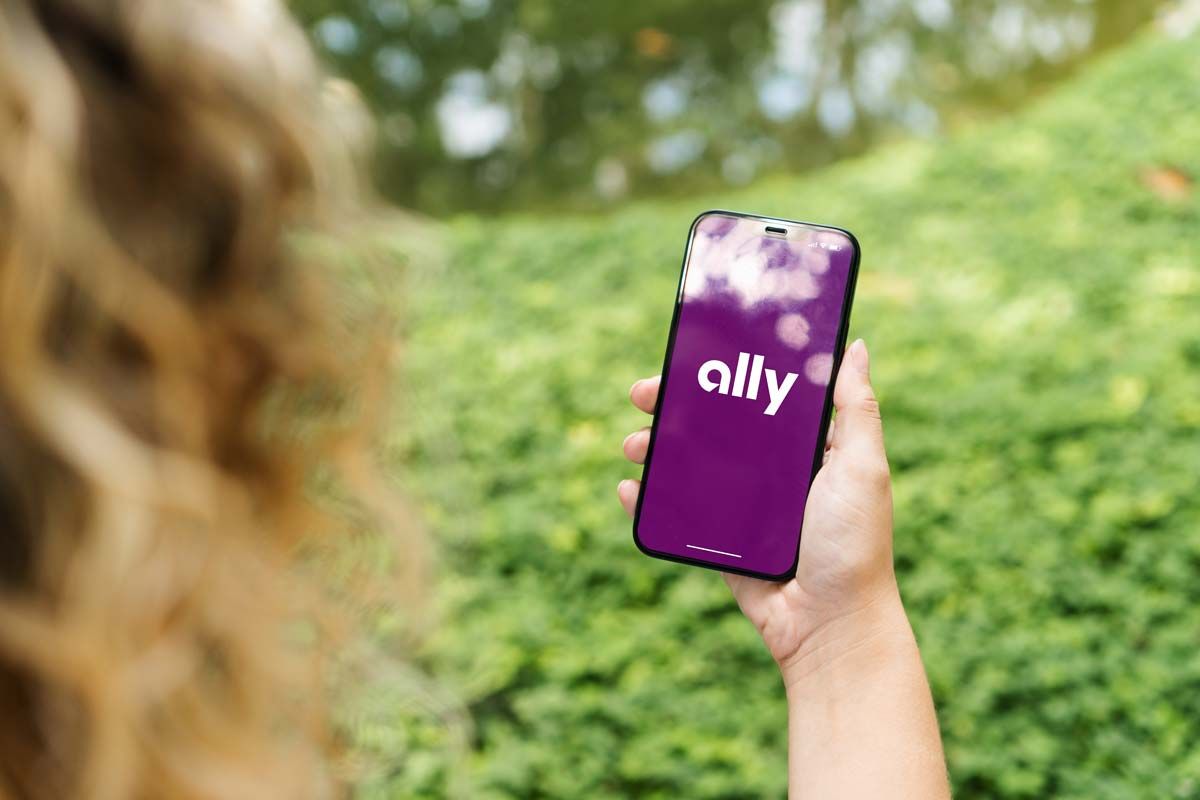 Close up of a woman using a smartphone with the Ally logo displayed, representing the Ally Financial class action.