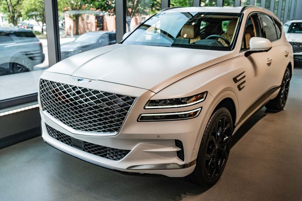 Front of a white Genesis GV80 in a showroom, representing the Hyundai Genesis recall.