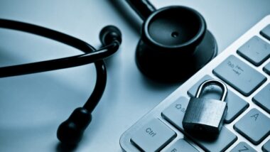 stethoscope over computer keyboard with a security lock, representing the Mercy Health data breach settlement.