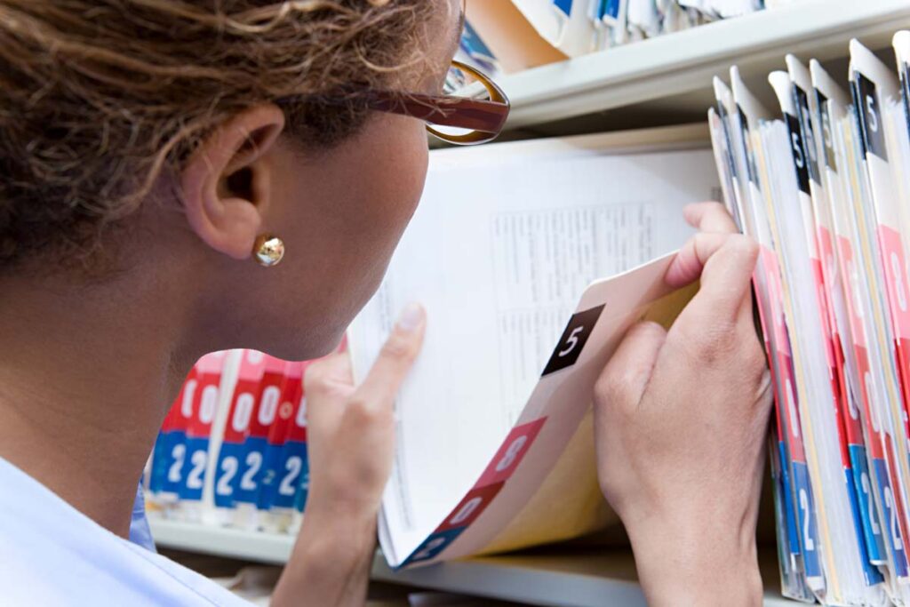 Close up of a female administrator looking at medical records, representing the MRO, Ciox and Medi-Copy settlement.