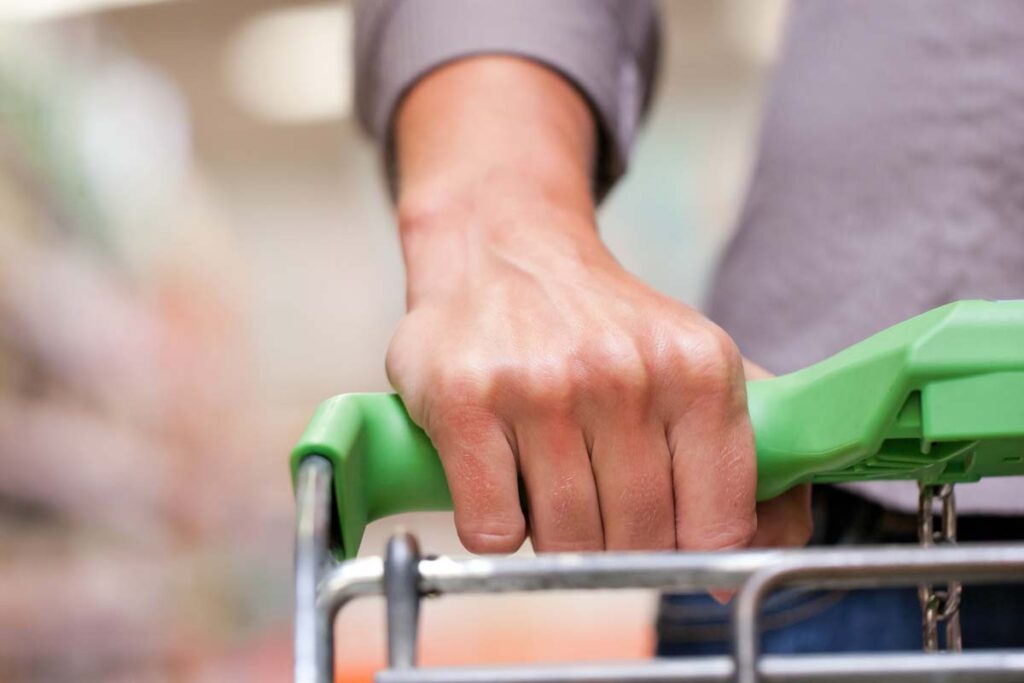 Close up of a hand on a shopping cart, representing top recalls for the week of April 29.