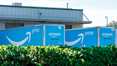 Amazon Prime delivery trucks loading and unloading online purchases at receiving dock of Amazon Fulfillment Center - Newark, California, USA