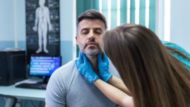 Doctor checking on thyroid patients thyroids.