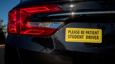 Yellow student driver sticker on car.