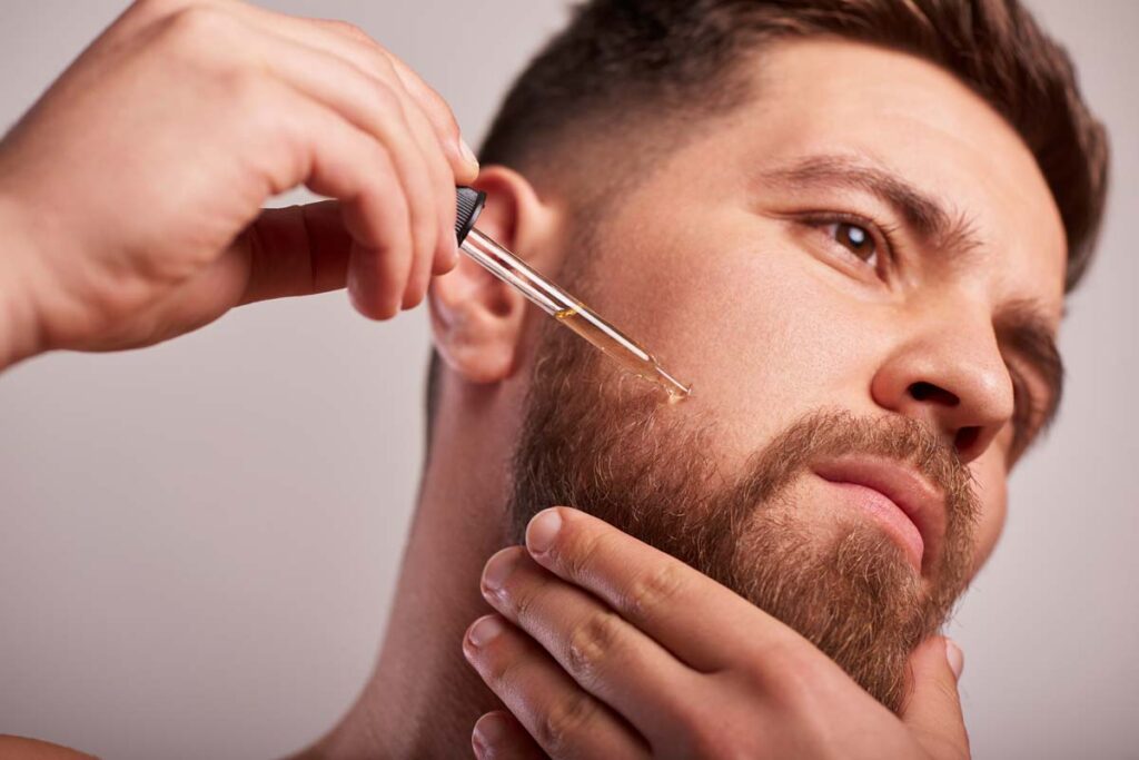 Close up of a man putting serum into his beard, representing the Beard Guyz class action.