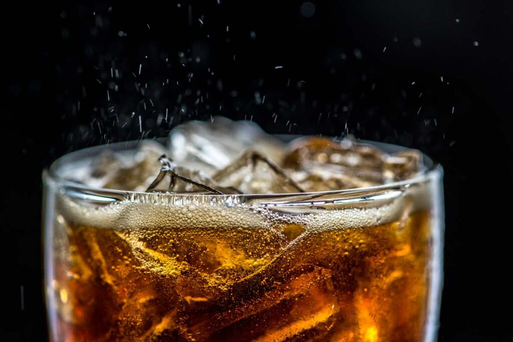 Close up of fizzy cola in a glass, representing the soft drink recall.