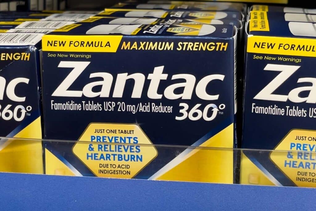 A close-up of Zantac products for sale on a supermarket shelf, symbolizing the Zantac lawsuits.