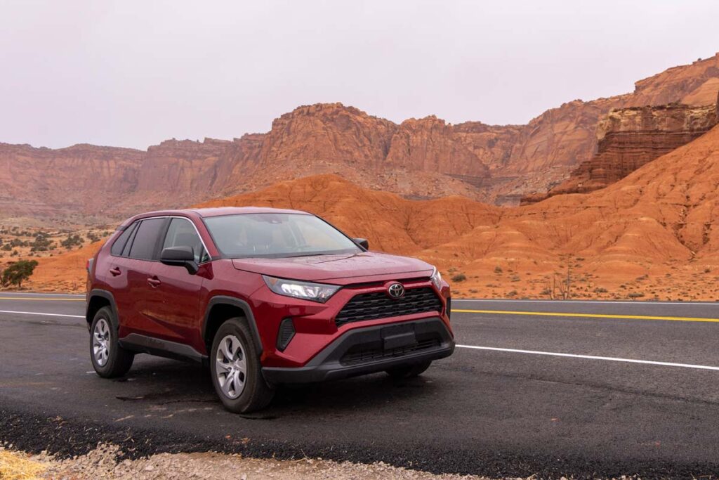 A red 2022 Toyota RAV4 parked on the side of a scenic road, representing the Toyota class action.