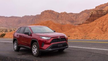 A red 2022 Toyota RAV4 parked on the side of a scenic road, representing the Toyota class action.