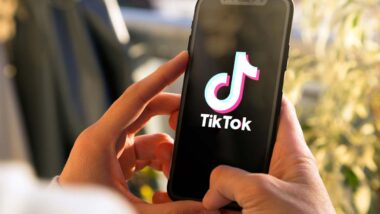 Close up of hands holding a smartphone with the TikTok logo displayed, representing the TikTok lawsuit.