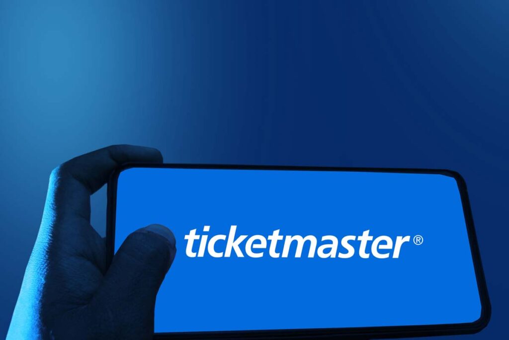 Close up of hand holding a smartphone with the Ticketmaster logo displayed, representing the Ticketmaster data breach.