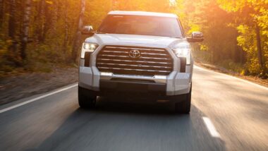 A white Toyota Tundra driving on a scenic road, representing the Toyota recall.