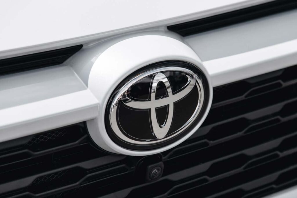Close up of a Toyota emblem on a front bumper, representing the Toyota recalls.