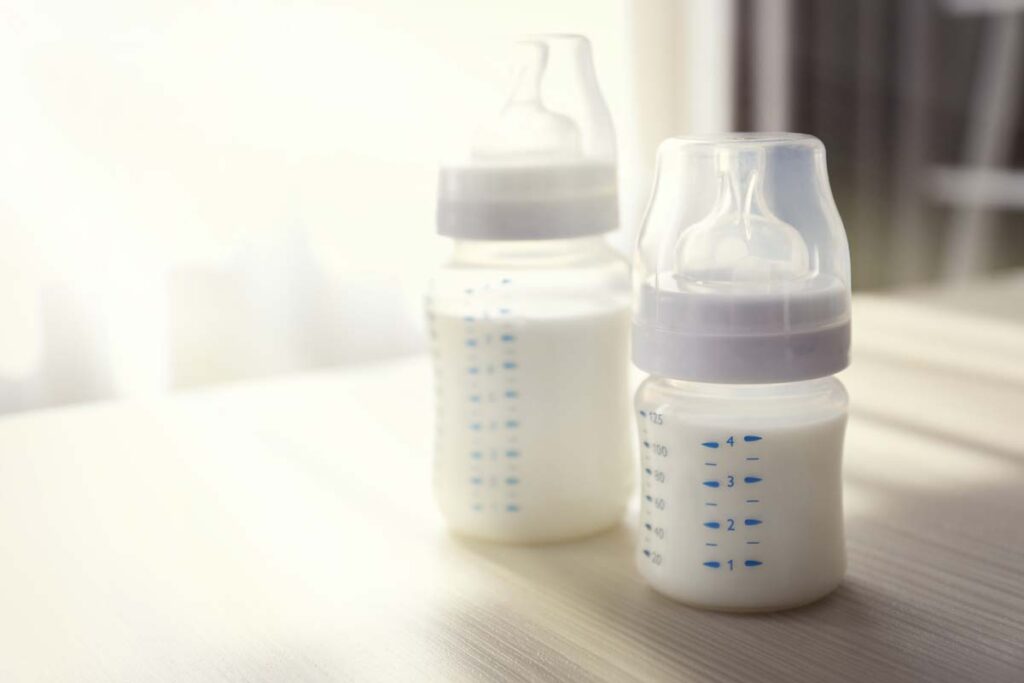 Close up of baby bottles filled with milk on a tabletop, representing the Philips class action.