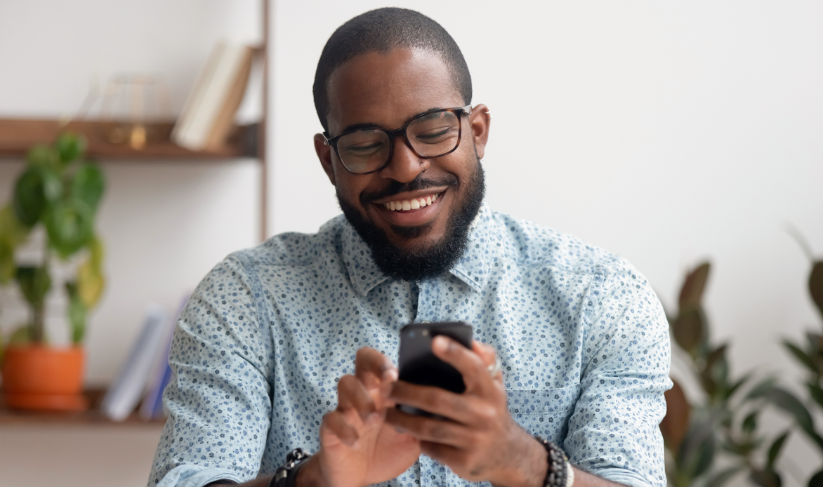 Man happily playing solitaire on smart phone.