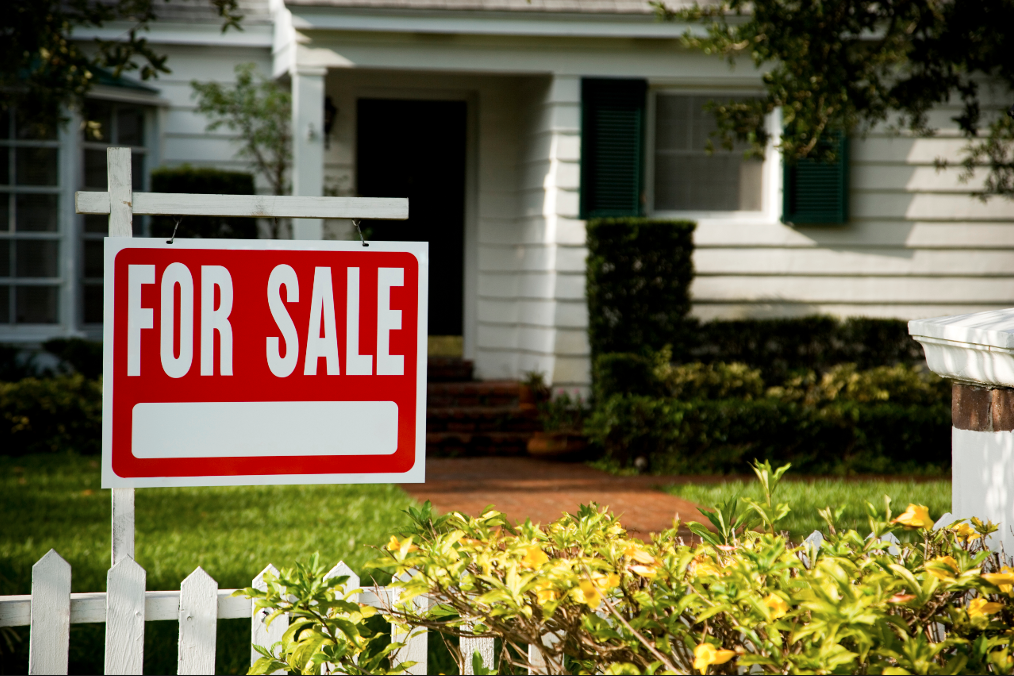 House with a generic for sale sign in front yard.