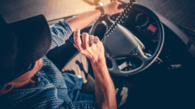 Semi Truck Driver Making Conversation with Other Truck Drivers Through CB Radio.