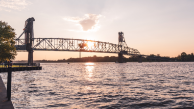 Burlington Bristol Bridge vertical lift bridge in New Jersey and Pennsylvania at sunset with purple golden sky.