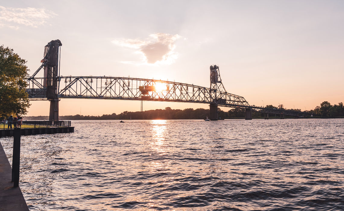 Burlington Bristol Bridge vertical lift bridge in New Jersey and Pennsylvania at sunset with purple golden sky.