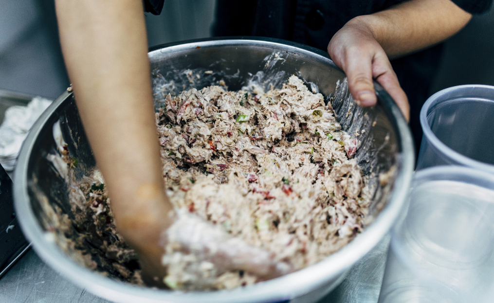 Kitchen staff making large quantity of tuna salad