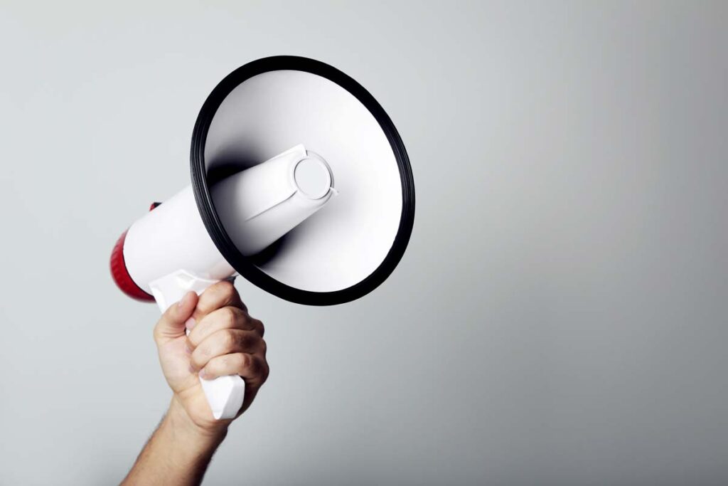 Close up of a hand holding a megaphone, representing top recalls for the week of July 22.