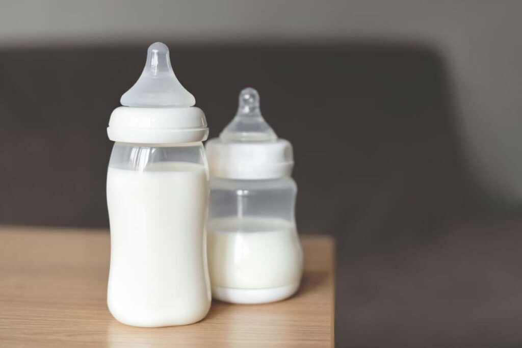 On a table are baby bottles filled with milk, representing the baby bottle class action lawsuits.