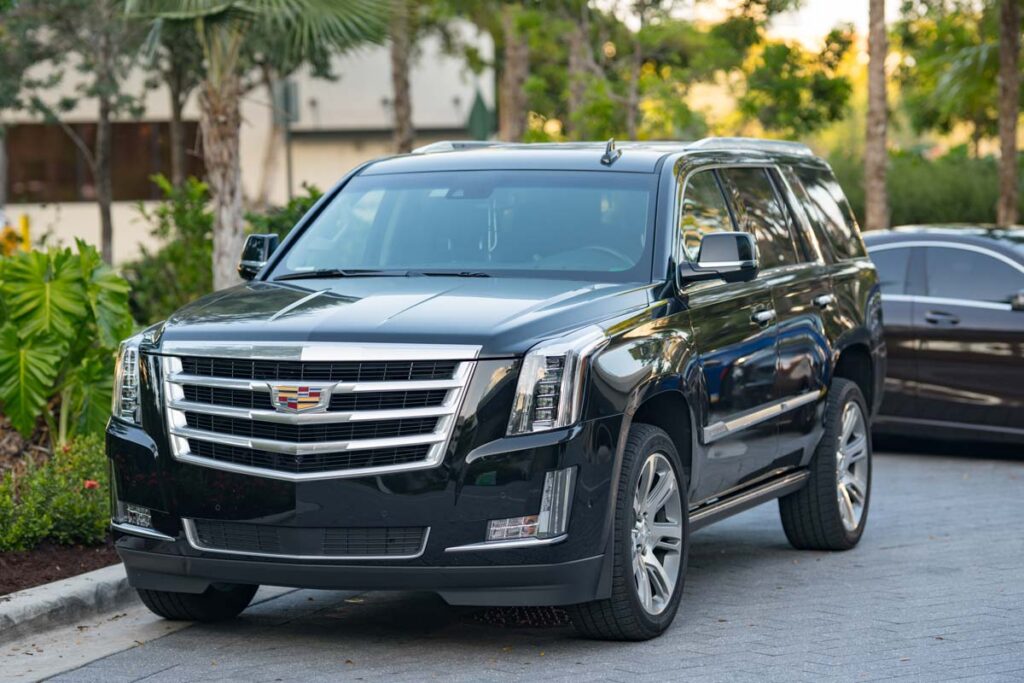 A black Cadillac Escalade parked on a street represents GM's class action lawsuit.