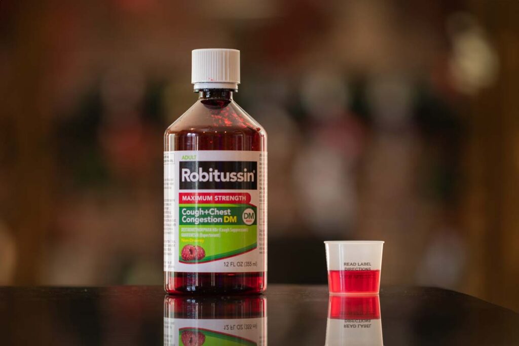 Robitussin bottle on a kitchen counter, representing Robitussin settlement.