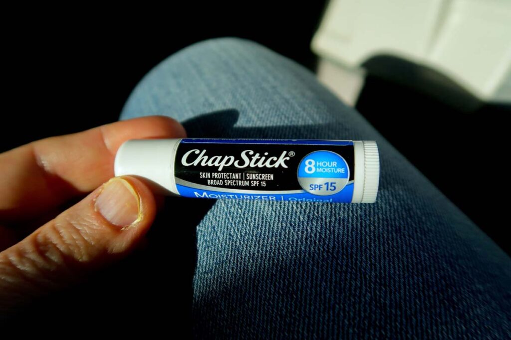 Close up of a hand holding a. Chap Stick brand product, representing the ChapStick settlement.