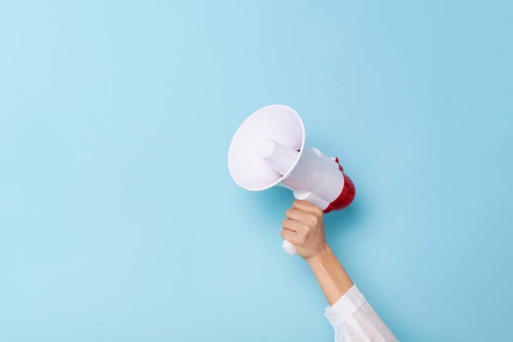 A hand holding a megaphone against an isolated background, representing top recalls for the week of July 8.