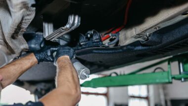 A mechanic replacing a fuel pump on a diesel car, representing GM fuel pump class action settlement.