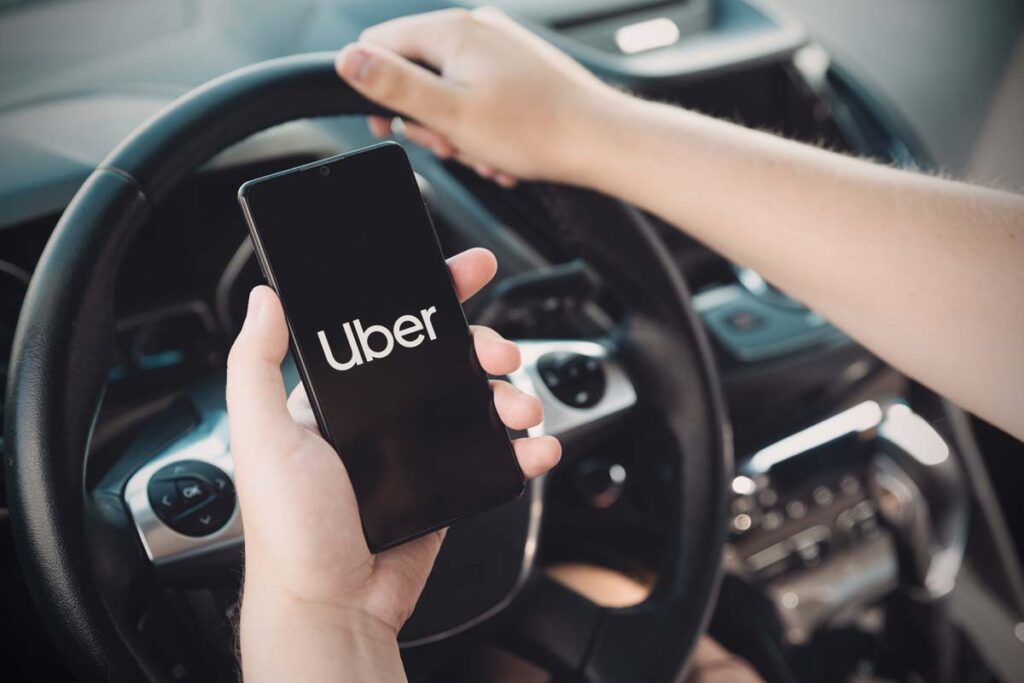 Uber logo displayed on smartphone screen, representing Uber delivery fee class action lawsuit.