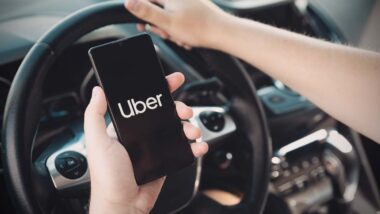 Uber logo displayed on smartphone screen, representing Uber delivery fee class action lawsuit.