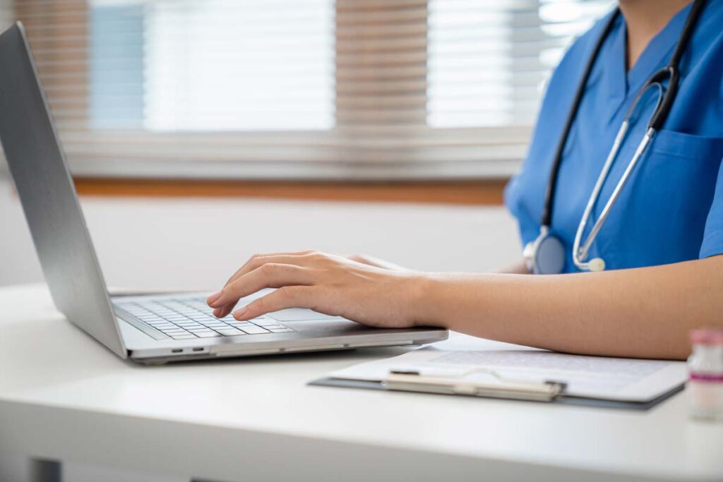 Close-up of a nurse typing on a laptop representing the PruittHealth class action lawsuit.