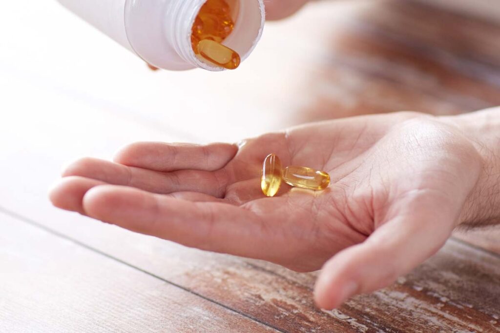 Close up of fish oil softgels being poured into a hand, symbolizing the fish oil supplement class action lawsuit.