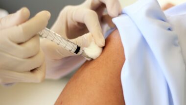 Vaccine injected into deltoid muscle and using the cotton to stop bleeding while pulling the needle out.
