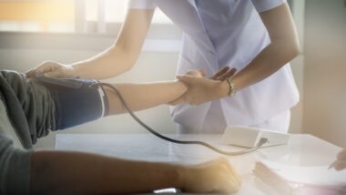 Nurse practitioner taking blood pressure