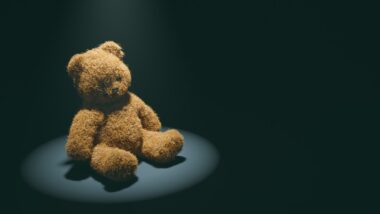 teddy bear underspotlight missing an eye, child abuse concept.