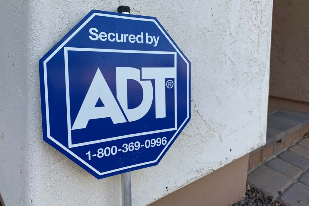 Close up of ADT monitoring sign on exterior of a home, representing the ADT data breach.