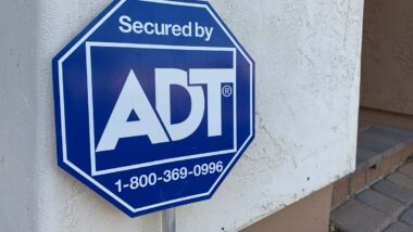 Close up of ADT monitoring sign on exterior of a home, representing the ADT data breach.