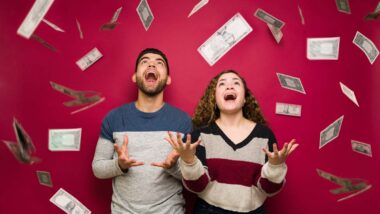 Young excited man and woman throwing cash into the air, representing recent class action rebates.