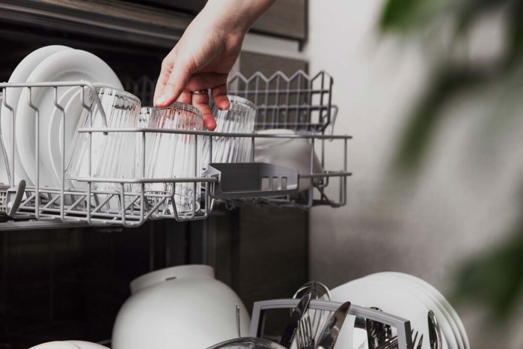 Close up of a woman loading a dishwasher, representing the Frigidaire class action.