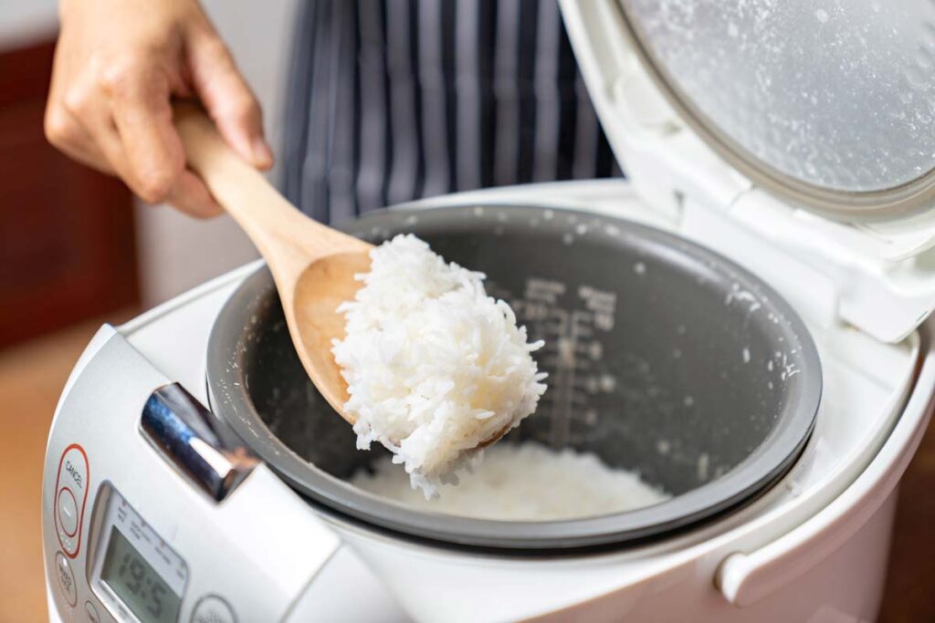 Close up of white rice being scooped out of a rice cooker, representing the Sunbeam class action.