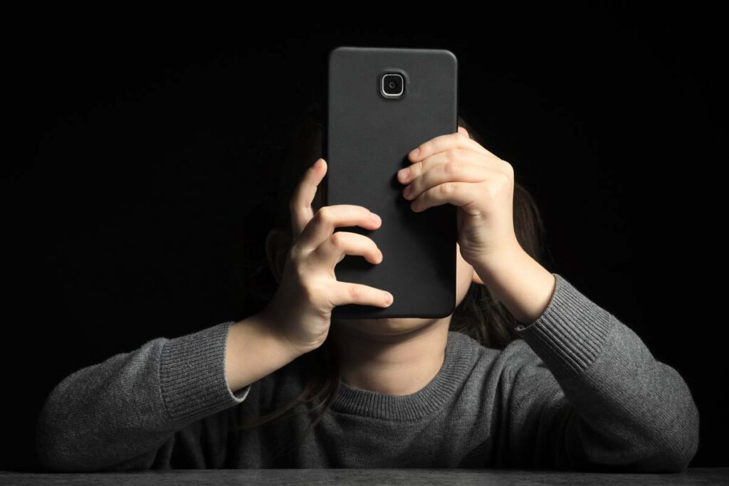 A young child using a smartphone, representing the Kids Online Safety Act.