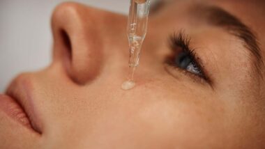 Close up of a woman putting a skincare serum on her face, representing the Pixi class action.