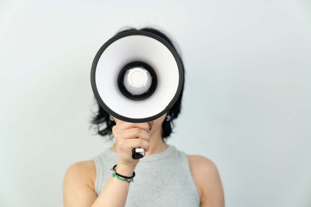 Close up of a woman using a megaphone, representing top recalls for the week of Aug. 12.