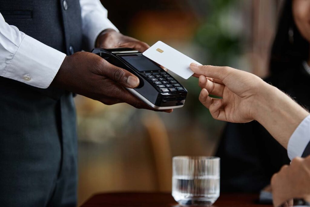 Close up of guest paying with credit card in luxury restaurant, representing the fee class actions.